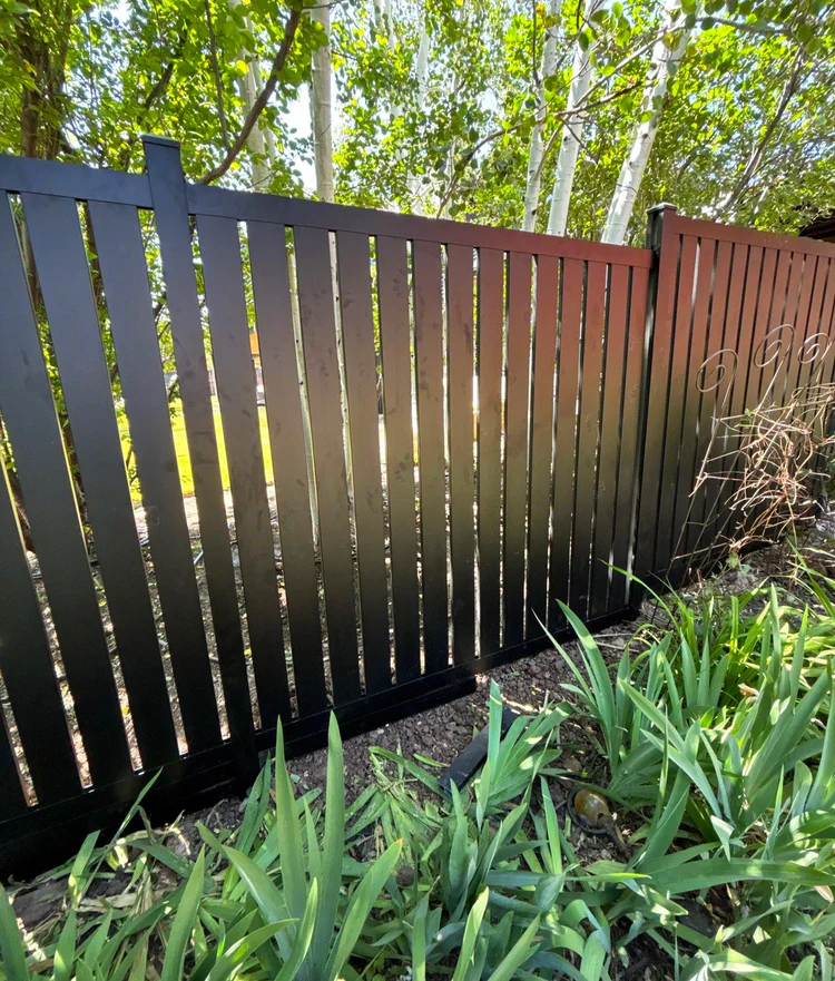 Professional fence installers working on a residential wooden privacy fence.